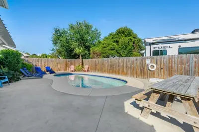 a backyard with a pool and a wooden fence at Anchors Away - Private Pool, Seasonal Hot Tub, Game Room, Walk to Beach, Pets OK in Panama City Beach