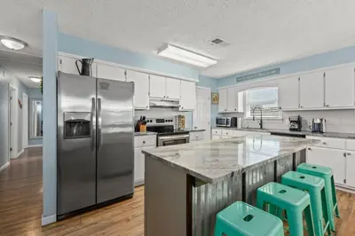 a large kitchen with a stainless steel refrigerator at Anchors Away - Private Pool, Seasonal Hot Tub, Game Room, Walk to Beach, Pets OK in Panama City Beach