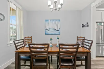 a dining room with a wooden table and chairs at Sandy Palms - Pool & Hot Tub, 3 Min Walk to the Beach, w Golf Cart & Beach Gear in Panama City Beach