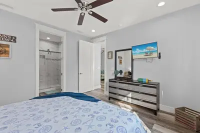 a bedroom with a bed and a ceiling fan at Sandy Palms - Pool & Hot Tub, 3 Min Walk to the Beach, w Golf Cart & Beach Gear in Panama City Beach