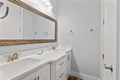 a white bathroom with a sink and a mirror at Sandy Palms - Pool & Hot Tub, 3 Min Walk to the Beach, w Golf Cart & Beach Gear in Panama City Beach