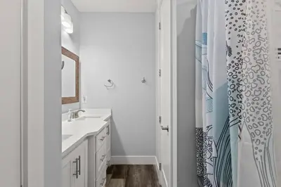 a bathroom with a sink and a shower curtain at Sandy Palms - Pool & Hot Tub, 3 Min Walk to the Beach, w Golf Cart & Beach Gear in Panama City Beach