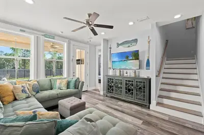 a living room with a couch and a tv at Sandy Palms - Pool & Hot Tub, 3 Min Walk to the Beach, w Golf Cart & Beach Gear in Panama City Beach
