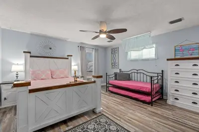 a bedroom with a twin bed and a dresser at Tiki Hut - Private Pool Home, Game Room, 5 Min Drive 2 Beach, FREE Daily Activities in Panama City Beach
