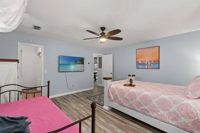 a bedroom with a bed and a ceiling fan at Tiki Hut - Private Pool Home, Game Room, 5 Min Drive 2 Beach, FREE Daily Activities in Panama City Beach