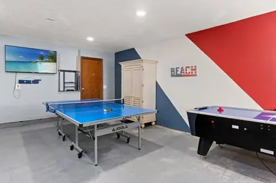 a ping pong table in a room with a wall at Tiki Hut - Private Pool Home, Game Room, 5 Min Drive 2 Beach, FREE Daily Activities in Panama City Beach