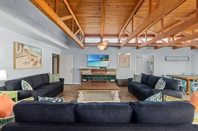 a living room with blue couches and a flat screen tv at Tiki Hut - Private Pool Home, Game Room, 5 Min Drive 2 Beach, FREE Daily Activities in Panama City Beach