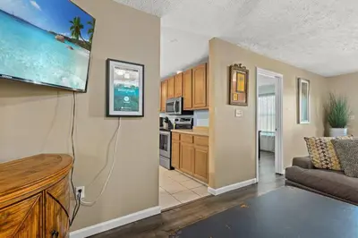 a living room with a couch and a kitchen at Pirates Cove - Private Pool, Seasonal Hot Tub, Game Room, Close to Beach, Pets OK in Panama City Beach