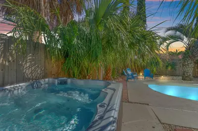 a hot tub in a yard with a patio and a chair at Pirates Cove - Private Pool, Seasonal Hot Tub, Game Room, Close to Beach, Pets OK in Panama City Beach