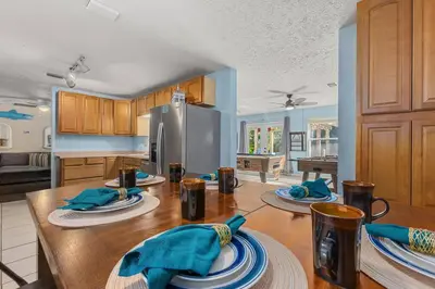 a kitchen with a wooden table with blue napkins on it at Pirates Cove - Private Pool, Seasonal Hot Tub, Game Room, Close to Beach, Pets OK in Panama City Beach
