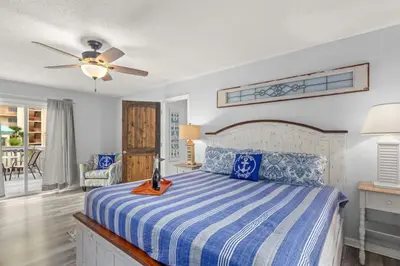 a bedroom with a bed and a ceiling fan at Sand Castle-Pool, Game Rooms, covered outdoor space with tiki bar, 1min walk to beach in Panama City Beach
