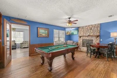 a living room with a pool table and a fireplace at Sand Castle-Pool, Game Rooms, covered outdoor space with tiki bar, 1min walk to beach in Panama City Beach