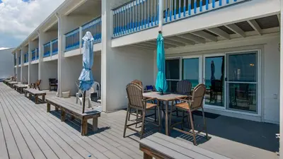 a deck with a table and chairs and umbrellas at Blue Nine 3 in Panama City Beach