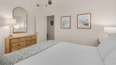 a bedroom with a bed and a dresser and a mirror at Blue Nine 3 in Panama City Beach