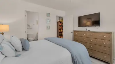 a bedroom with a bed with a television and a dresser at Blue Nine 3 in Panama City Beach