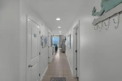 a hallway with white doors and a tile floor at Sterling Breeze 804 in Panama City Beach