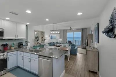 a kitchen and living room with a view of the ocean at Sterling Breeze 804 in Panama City Beach