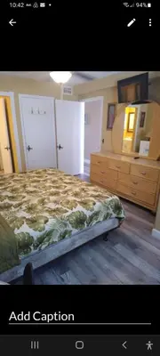 a bedroom with a bed and a dresser and a mirror at The Summit Condo Resort in Panama City Beach