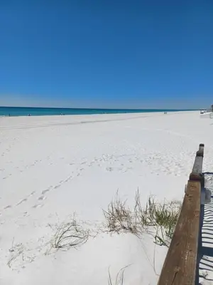 a boardwalk on a beach with the ocean in the background at The Summit Condo Resort in Panama City Beach