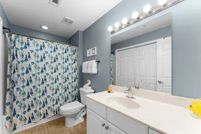 a bathroom with a sink and a toilet and a mirror at Totally Beachin Unit 1302 in Panama City Beach
