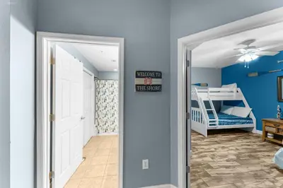 a hallway with a door leading to a bedroom with a bunk bed at Totally Beachin Unit 1302 in Panama City Beach