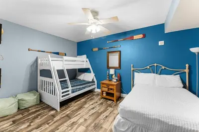 a bedroom with a white bunk bed and blue walls at Totally Beachin Unit 1302 in Panama City Beach