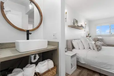 a bathroom with a sink and a bed with a mirror at Summit 808 - Luxury Beach Resort Condo 1-6 People in Panama City Beach