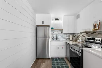 a kitchen with white cabinets and a stainless steel refrigerator at Summit 808 - Luxury Beach Resort Condo 1-6 People in Panama City Beach