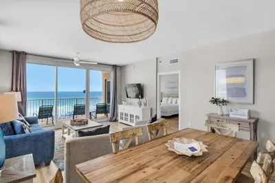 a living room with a table and a view of the ocean at Shores of Panama 431 in Panama City Beach