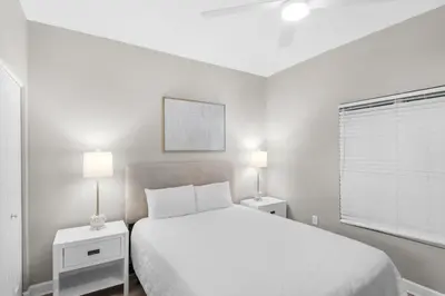 a white bedroom with a bed and two night stands at Shores of Panama 431 in Panama City Beach