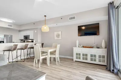 a kitchen and living room with a table and chairs at Shores of Panama 426 in Panama City Beach
