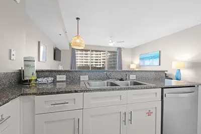 a kitchen with white cabinets and a sink at Shores of Panama 426 in Panama City Beach