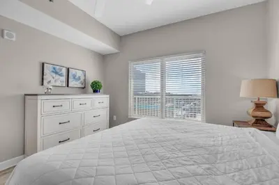 a white bedroom with a large bed and a window at Shores of Panama 426 in Panama City Beach