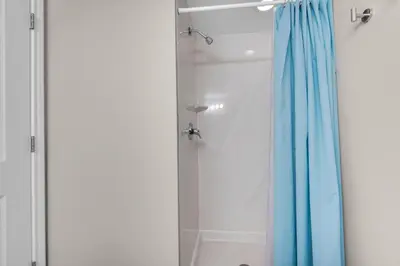 a shower with a blue shower curtain in a bathroom at Shores of Panama 426 in Panama City Beach