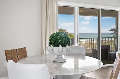 a dining room with a table with a plant on it at Serenity by the Sea in Santa Rosa Beach