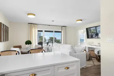 a kitchen and living room with a table and chairs at Serenity by the Sea in Santa Rosa Beach