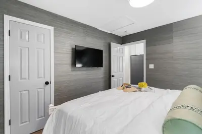 a bedroom with a bed and a tv on a wall at Serenity by the Sea in Santa Rosa Beach