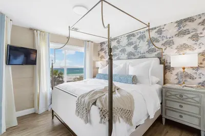 a bedroom with a canopy bed with a view of the ocean at Serenity by the Sea in Santa Rosa Beach