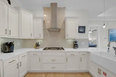 a white kitchen with white cabinets and a stove at Totally Beachin' in Inlet Beach