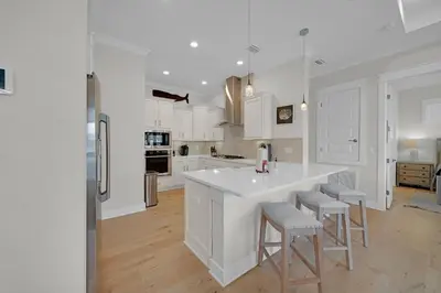 a kitchen with white cabinets and a large white island at Totally Beachin' in Inlet Beach