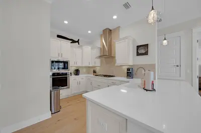 a kitchen with white cabinets and white counter tops at Totally Beachin' in Inlet Beach