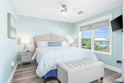 a white bedroom with a bed and a window at Beachside Villas #731 in Santa Rosa Beach