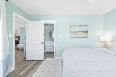 a white bedroom with a white bed and a door at Beachside Villas #731 in Santa Rosa Beach