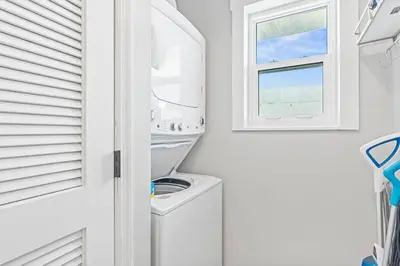 a white laundry room with a washing machine and a window at Beachside Villas #731 in Santa Rosa Beach