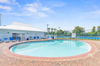 a swimming pool with chairs and a building at Beachside Villas #731 in Santa Rosa Beach