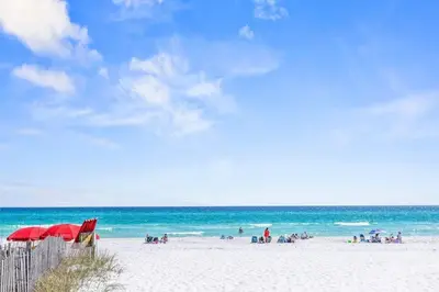 a group of people on a beach with the ocean at Beachside Villas #731 in Santa Rosa Beach