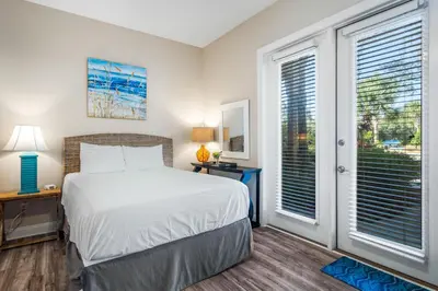 a bedroom with a bed and a window at LUV PCB by Sand Seeker Vacations in Panama City Beach