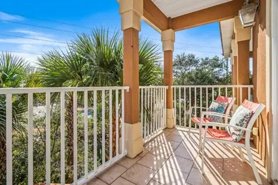 a porch with a white fence and a chair at LUV PCB by Sand Seeker Vacations in Panama City Beach