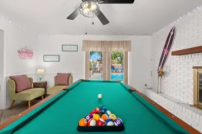 a pool table with balls on it in a living room at Flirty Flamingo with Private Heated Pool, Game Room, and AMAZING Covered Outdoor Living in Panama City Beach