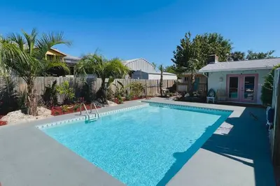 a swimming pool in front of a house at Flirty Flamingo with Private Heated Pool, Game Room, and AMAZING Covered Outdoor Living in Panama City Beach
